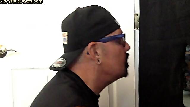Tattooed DILF sucks cock through gloryhole till cum in mouth