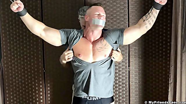 Muscular dude tied up and gets his feet and body tickled by a perv