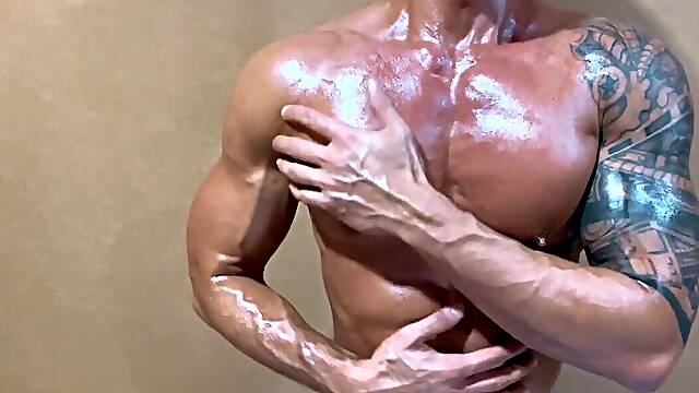 Idolize this hot lubed up Asian muscle hunk as he display off his big pecs and play with his nipples