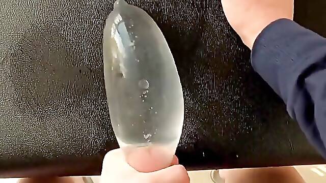 A Single Boy Masturbates and Moans at Home, Shooting Into a Water Ball in a Condom