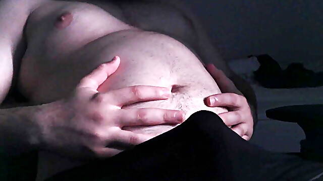 Chubby guy plays with his belly, masturbates and cums on his belly