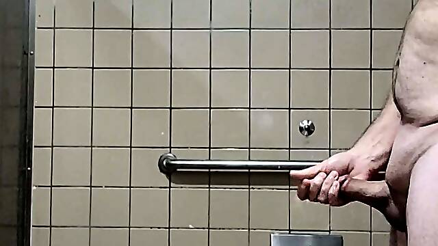 More old guy naked and masturbating in big mens room stall