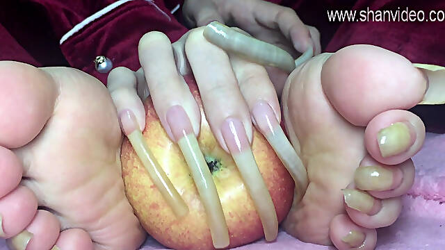 Long toenails girl plays with an apple