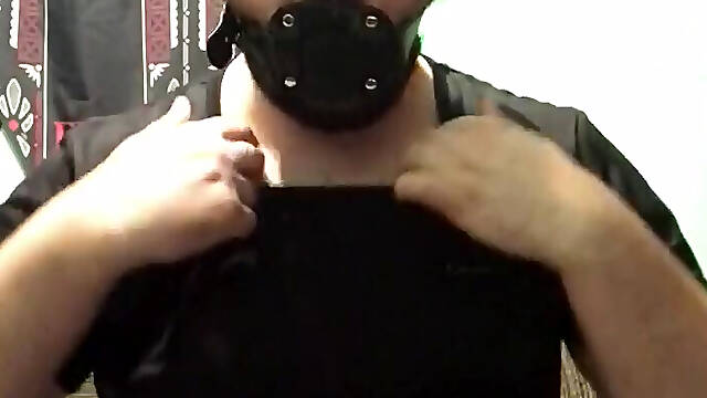 A man puts a gag in his mouth and an anal plug